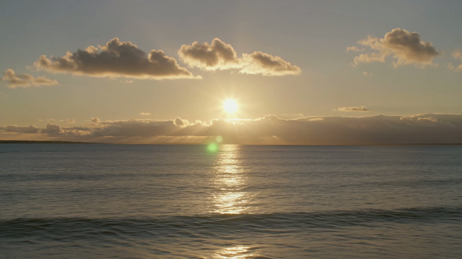 A calm golden-hour ocean scene, the kind of atmospheric AI-generated backdrop used behind lyric video text.