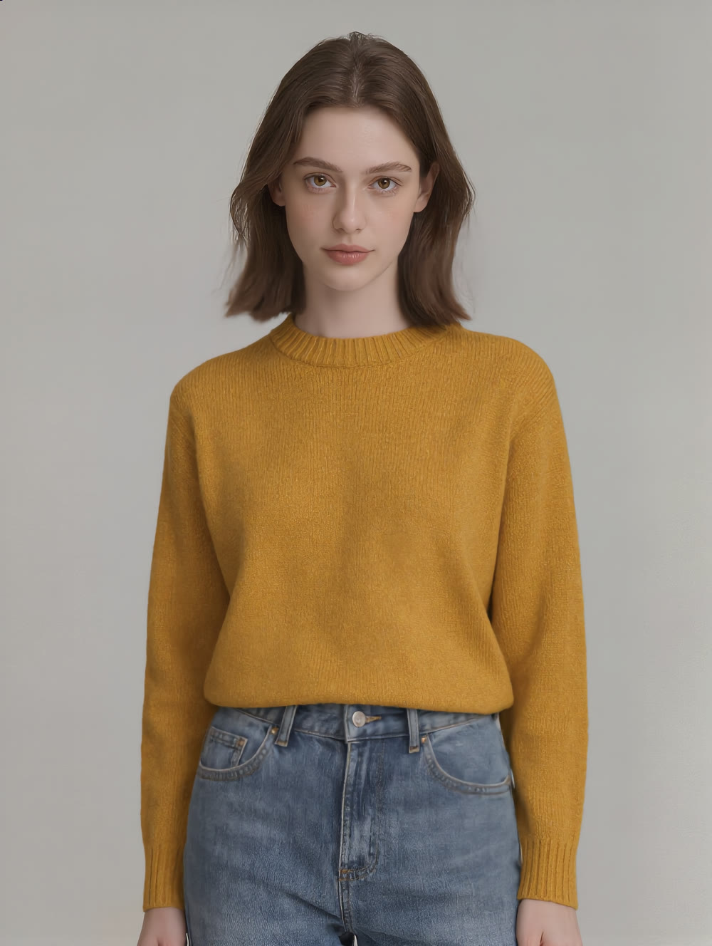 The same model in the same pose and background, now wearing a mustard yellow oversized knit sweater.